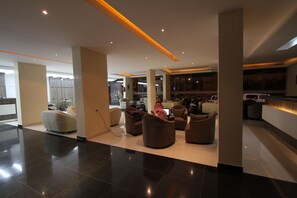 A spacious lobby with modern furniture, a kitchen area, and a bar. - Raoum Inn Serviced Apartments-Majmaa (Al Majmaah)