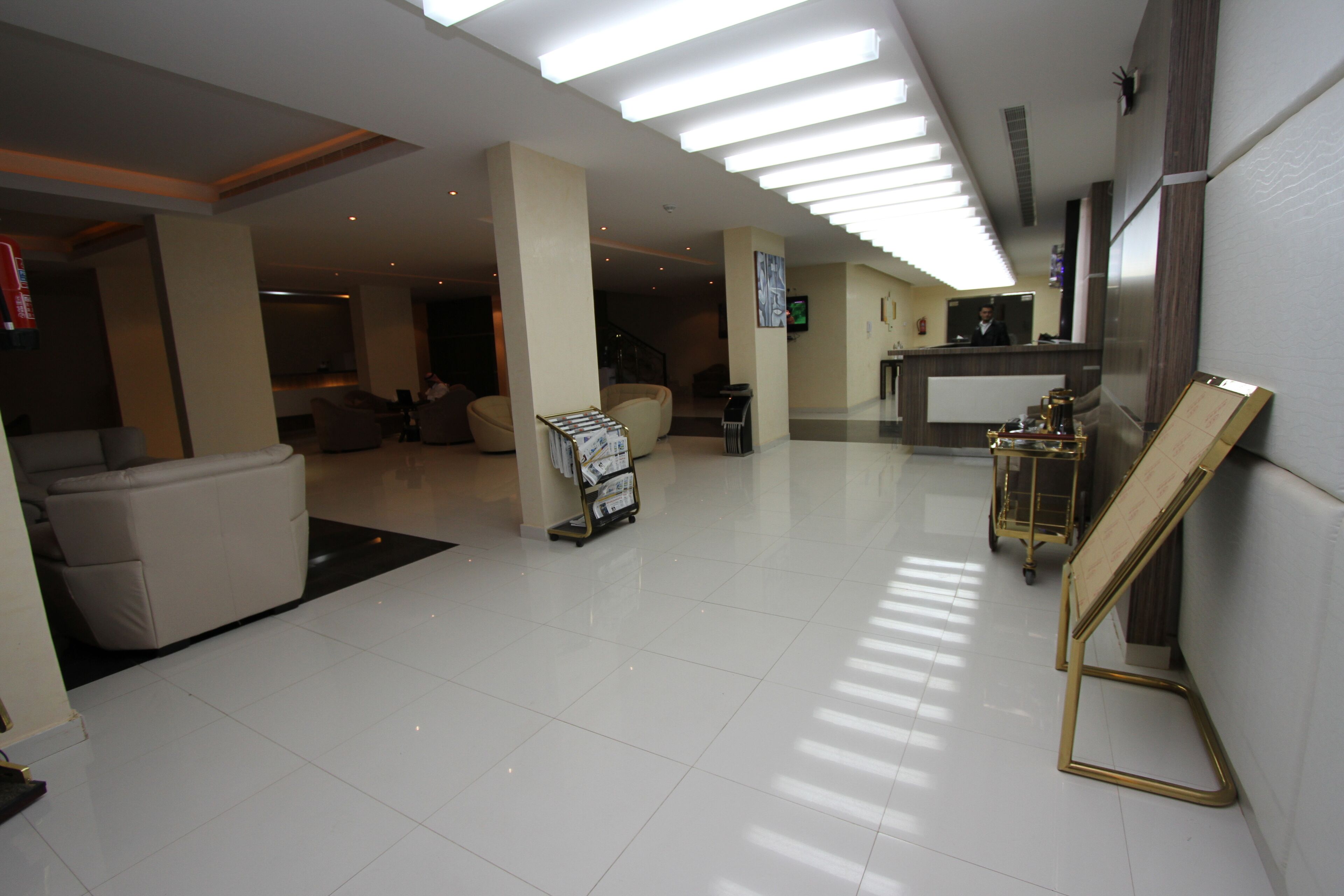 A spacious lobby with a reception desk, seating area, and a large window.
