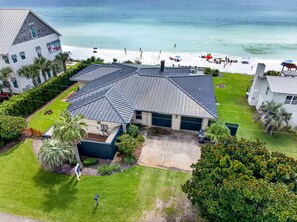 A beachfront property with a large house, a well-maintained lawn, and a view of the ocean. - The Point - Oceanfront Home in Blue Mountain Beach with Direct Beach Access (Santa Rosa Beach)