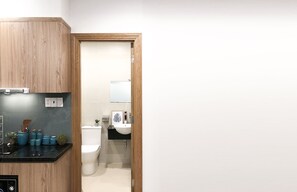 A modern bathroom with a toilet, sink, and wooden cabinetry. - The Art - Bong Gio House (Ho Chi Minh City)