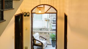 A hallway leading to a balcony with a chair and a potted plant. - The Art - Bong Gio House (Ho Chi Minh City)