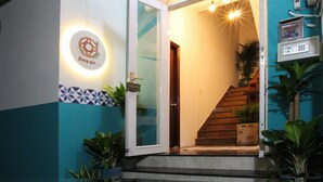 A hotel entrance with a welcoming sign, a staircase, and potted plants. - The Art - Bong Gio House (Ho Chi Minh City)
