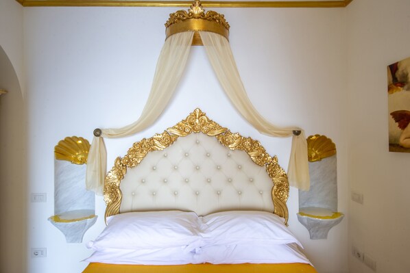A luxurious bed with a tufted headboard, draped canopy, and gold accents. - PALAZZO ROCCO ALL 3 VILLAS - 7 Bedrooms - 7 Bathrooms - Heated Jacuzzi - 20 pax. (Praiano)