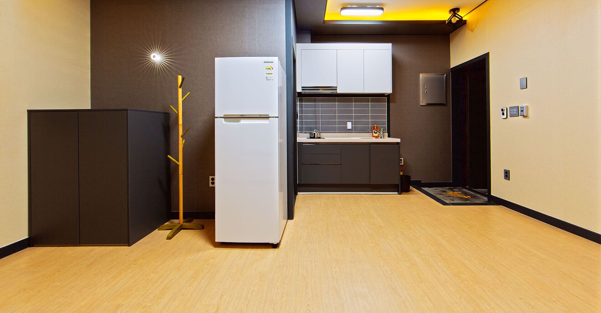 A compact kitchen with a refrigerator, a microwave, and a sink.