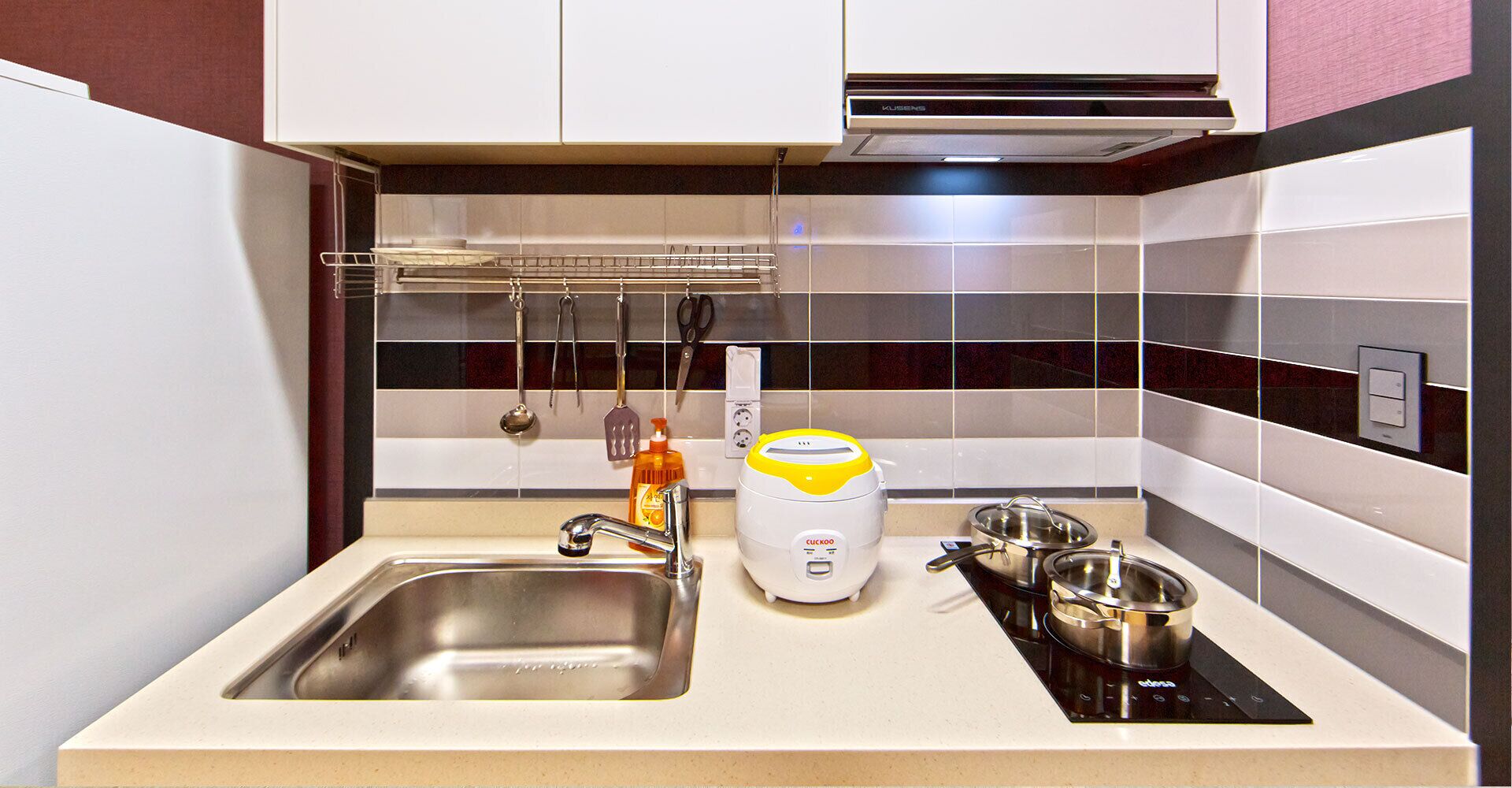 A modern kitchen with a stainless steel sink, a built-in toaster, and a stove.