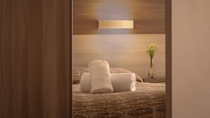 A bedroom with a bed, a bedside table with a vase of flowers, and a wall-mounted light fixture. - Foresteria Valdese di Firenze - Casa per Ferie (Florence)