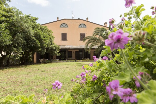 A building with a symmetrical facade, arched windows, and a flat roof. - Casa Valdese di Rio Marina - Casa per Ferie (Rio)