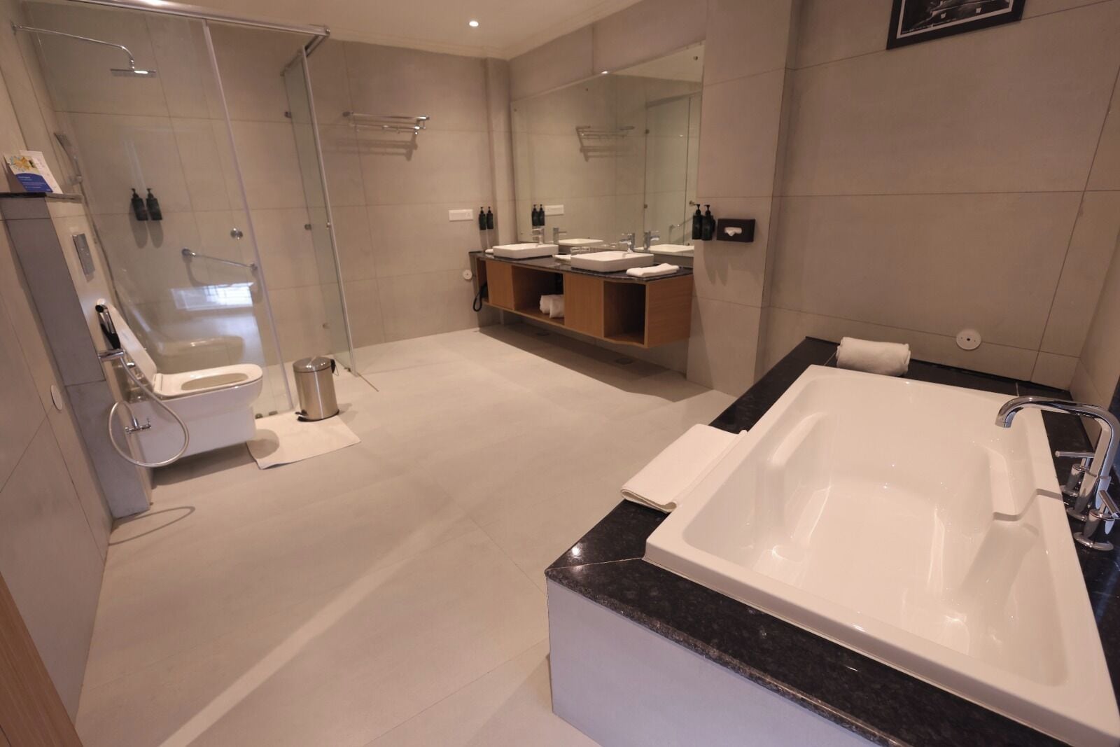 A modern bathroom with a glass-enclosed shower, a freestanding bathtub, and a vanity with two sinks.