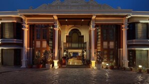 A grand hotel entrance with a cobblestone driveway, large columns, and a central archway. - Ramada by Wyndham Mussoorie Mall Road (Dehradun)