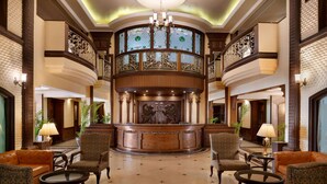 A grand lobby with a central reception desk, ornate railings, and classic furniture. - Ramada by Wyndham Mussoorie Mall Road (Dehradun)