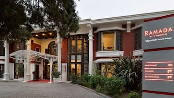 Entrada de un hotel con un cartel que indica servicios como acceso para vehículos, banquetes y una zona de recreación.