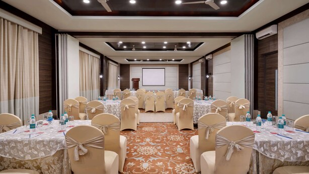 A conference room with tables set for a meeting, arranged in a U-shape with chairs.