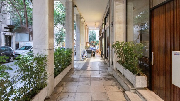 A covered corridor with a tiled floor, columns, and potted plants. - A short walk to Syntagma and Plaka (Athens)