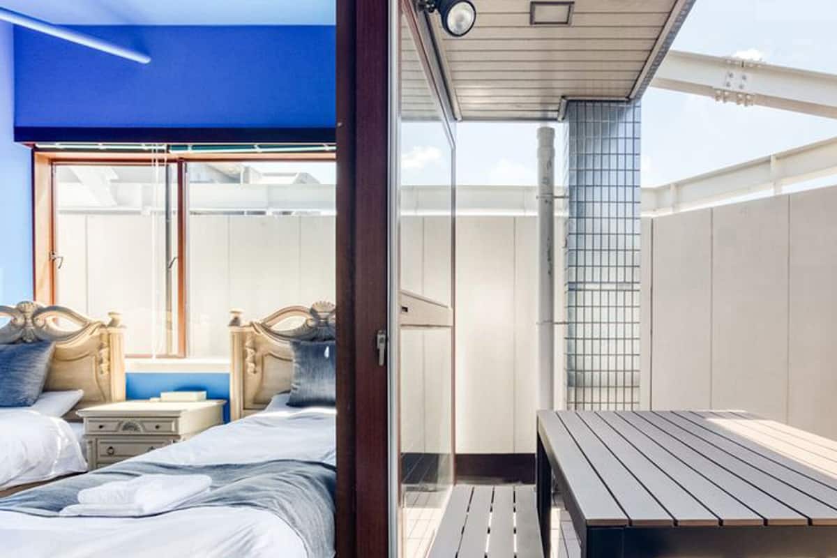 Une chambre à coucher avec un lit, des tables de chevet et une fenêtre.
