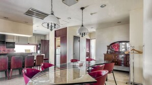 A modern kitchen with a central island, red chairs, and pendant lighting. - Woo House (Osaka)