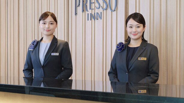 Two individuals standing in front of a wall with the text 'PRESSO INN' visible. - Keio Presso Inn Kanda (Tokyo)