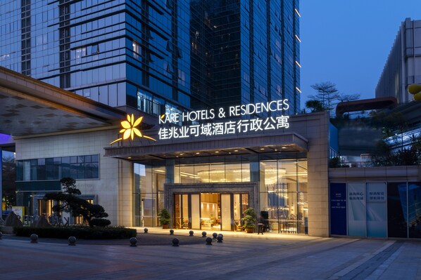 A hotel entrance with a modern glass facade, a prominent sign, and a well-lit entrance area. - Kare Hotels (Shenzhen)