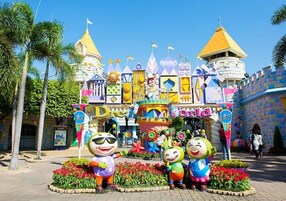 Un edificio colorido con fachada que recuerda a un castillo, palmeras y un letrero que dice 'Dream World'.