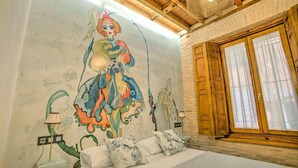 A bedroom with a mural, wooden ceiling, and a large window with curtains. - DELUX APARTMENT CASA DEL ANILLO TOLEDO (Toledo)