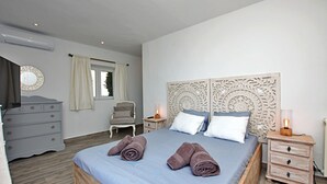 A bedroom with a bed, two bedside tables, a dresser, a chair, and a window with curtains. - Luxury villa with spectacular sea views, Pvt Pool, Gardens and Parking (Teulada)