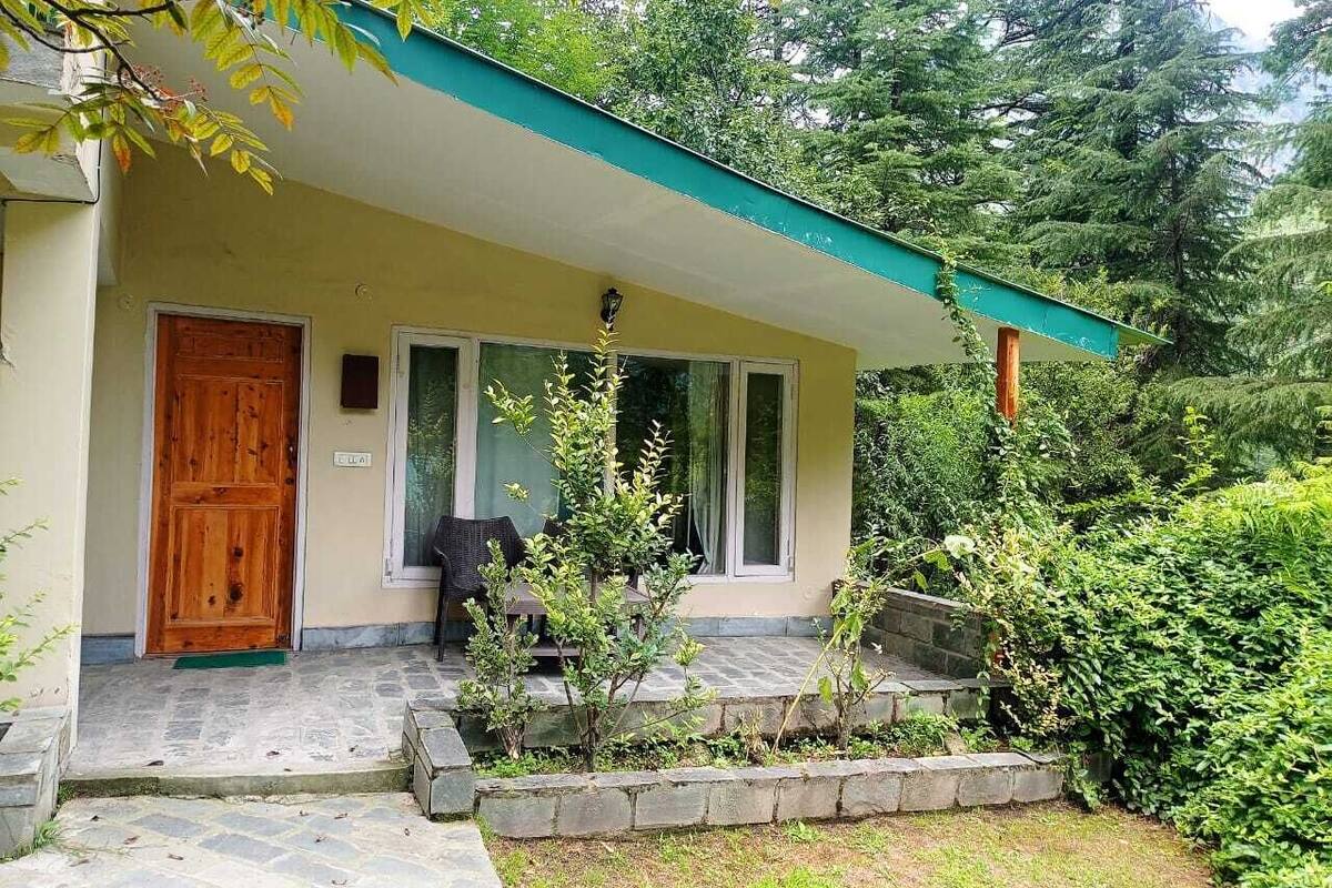 A house with a wooden door, a covered porch, and a stone pathway leading to the entrance.