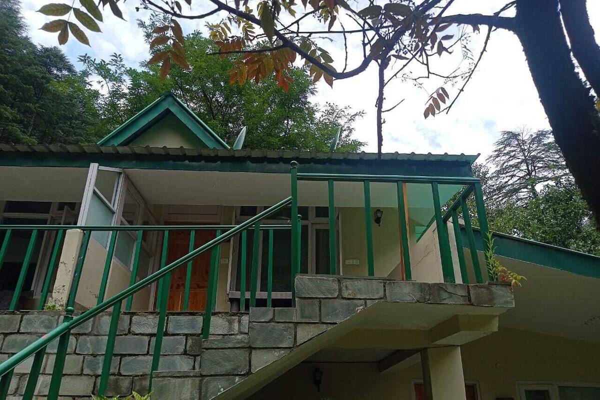 A two-story building with a green staircase leading to a balcony.