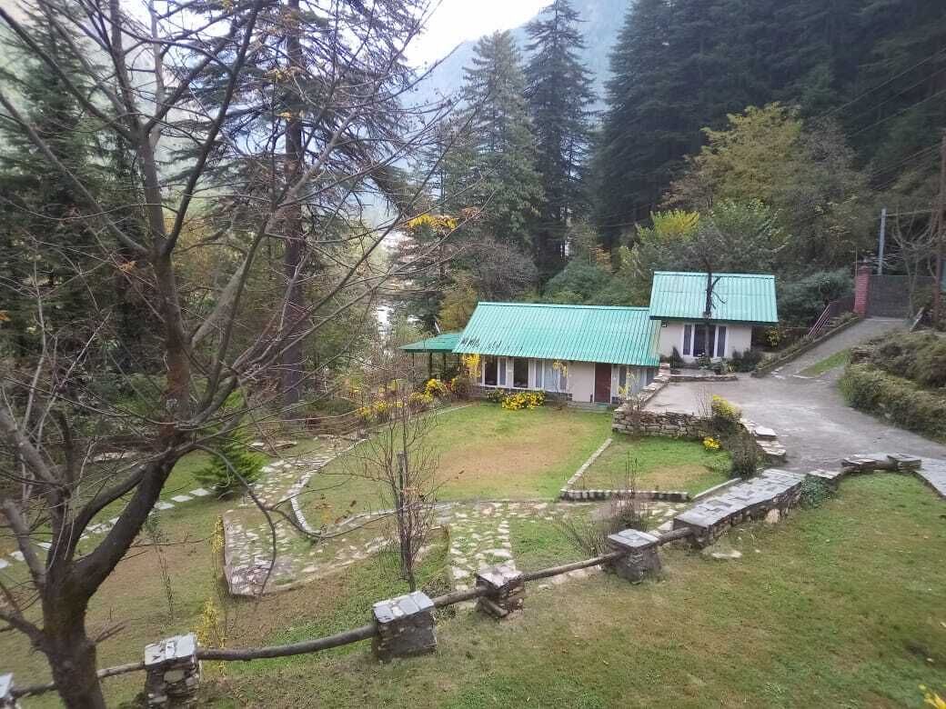 Ein zweistöckiges Gebäude mit Gründach, umgeben von einem Steinweg und einem kleinen Garten.