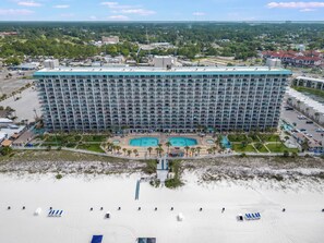 A large hotel with multiple floors, a pool area, and a beach in the foreground. - The Summit 618 - Stunning Waterfront Condo (Panama City)
