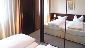 A hotel room with a bed, a nightstand, a lamp, and a painting on the wall. - As-Salam Aparthotel (Friedrichsdorf)