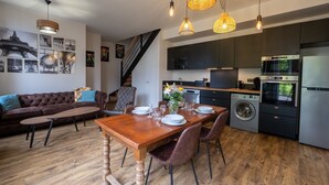 Una cucina moderna con mobili scuri, forno integrato e lavatrice.