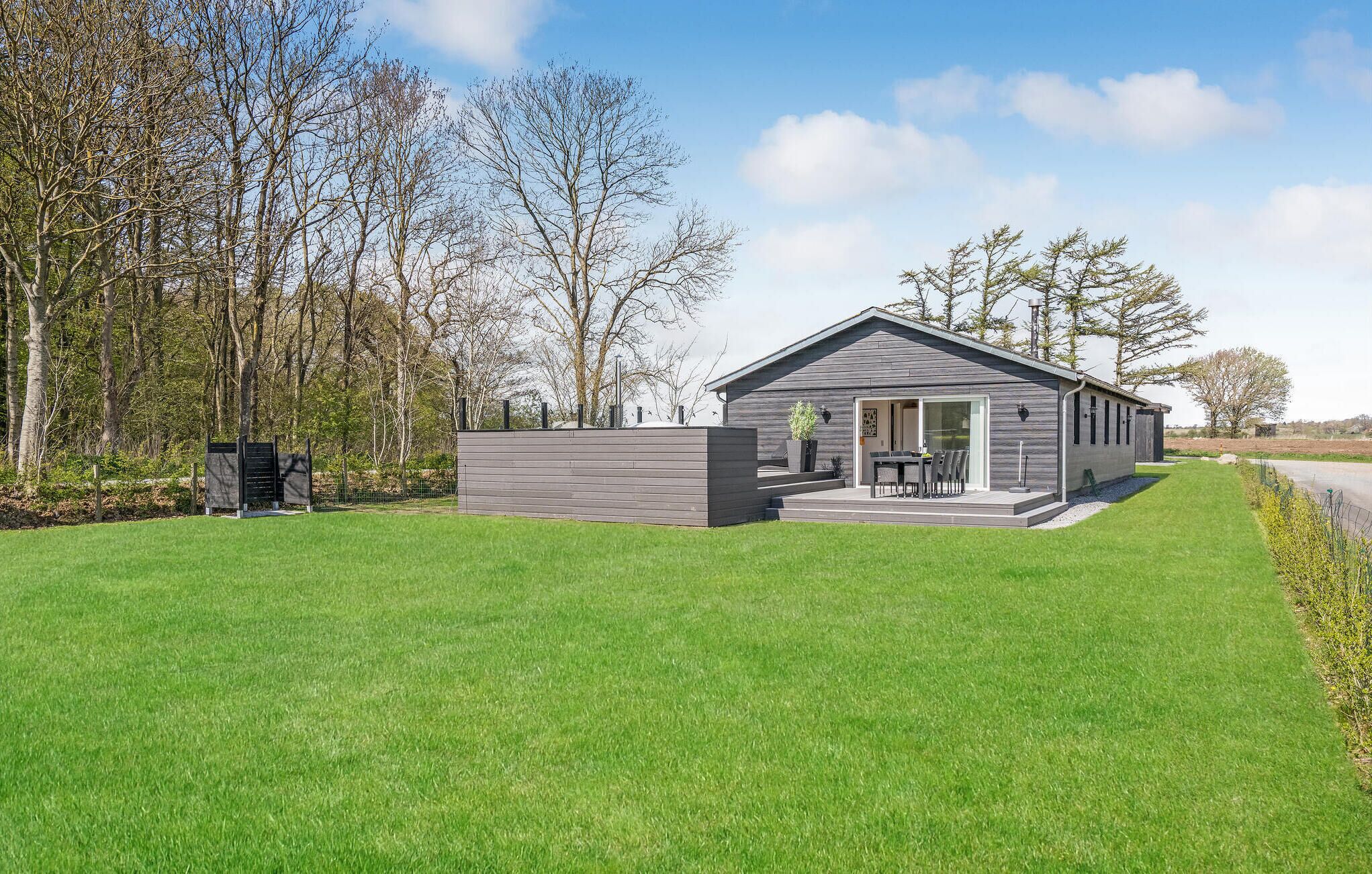 A modern, single-story house with a patio and a covered outdoor seating area.