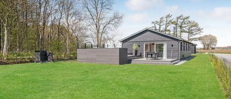 A modern, single-story house with a patio and a covered outdoor seating area.