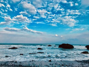 A beach with waves and rocks under a partly cloudy sky. - Utopia Hostel (Taitung)