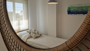 A room with a circular wicker bed, a window, a wall painting, and a hanging lamp. - bungalow - Formentera (La Savina)
