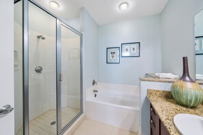 Een bad/douchecombinatie, handdoeken