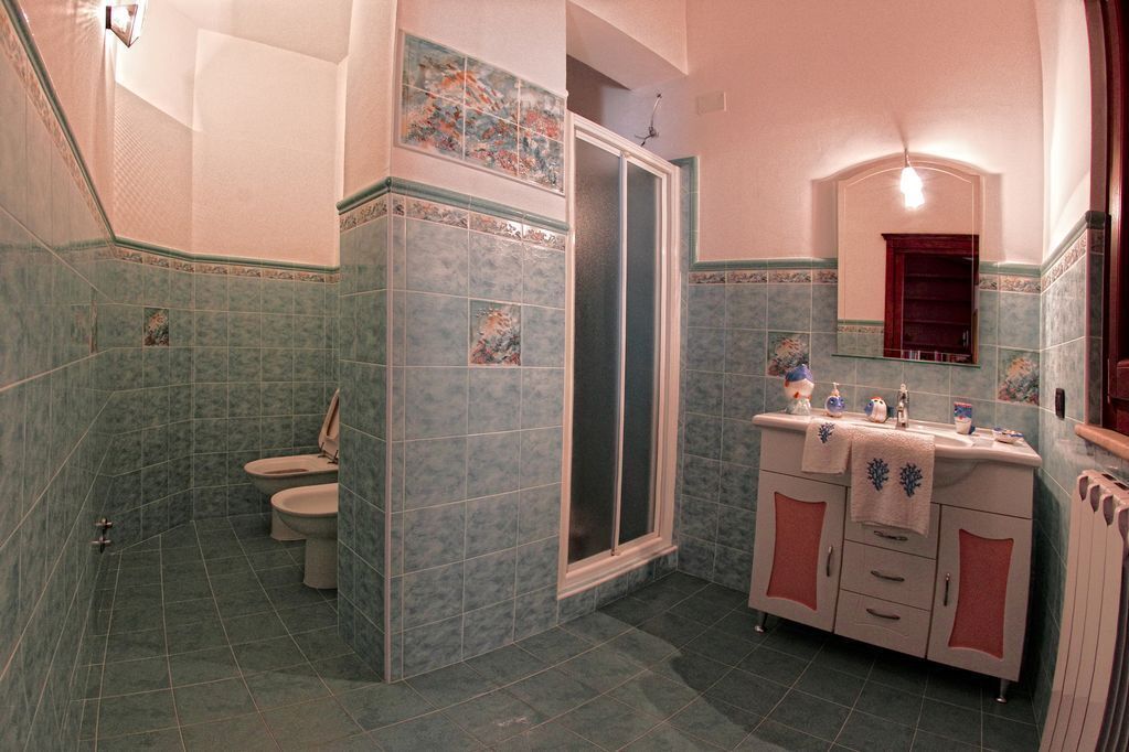 Un bagno con doccia, toilette e lavabo con specchio.