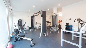 A gym with various exercise equipment, including weight machines, free weights, and cardio machines.
