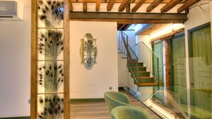 A hallway with a wooden ceiling, a staircase, and a glass partition with decorative elements. - SYNAGOGUE 6 DELUXE WITH PRIVATE TERRACE (Toledo)