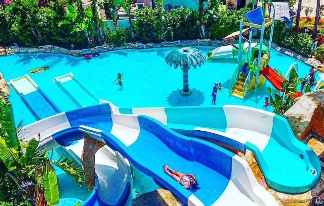 Un parc aquatique doté de nombreux toboggans et d’une grande fontaine centrale.