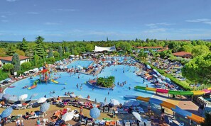 A large outdoor swimming pool complex with multiple water slides and a surrounding area with sun loungers and umbrellas. - Victoria Mobilehome Bella Italia (Peschiera del Garda)