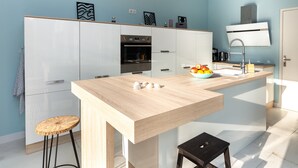 A modern kitchen with white cabinets, a wooden countertop, a built-in oven, and a sink with a faucet. - Villa Takamira - heated pool and spacious garden close to Golf and Beaches (Soorts-Hossegor)