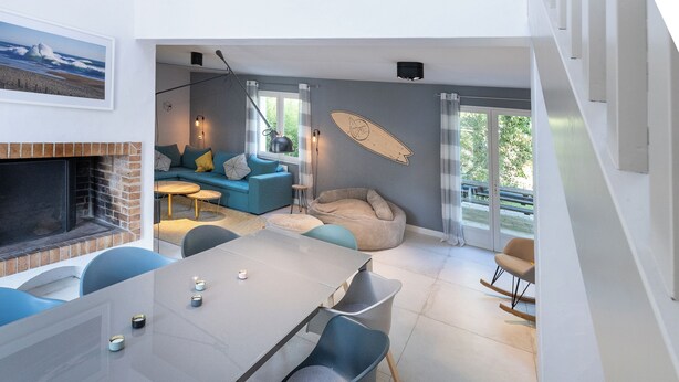 A modern living space with a dining area, a sofa set, a bean bag, and a fireplace. - Villa Takamira - heated pool and spacious garden close to Golf and Beaches (Soorts-Hossegor)