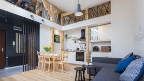 Une cuisine moderne avec des meubles blancs, une hotte noire et un four encastré.