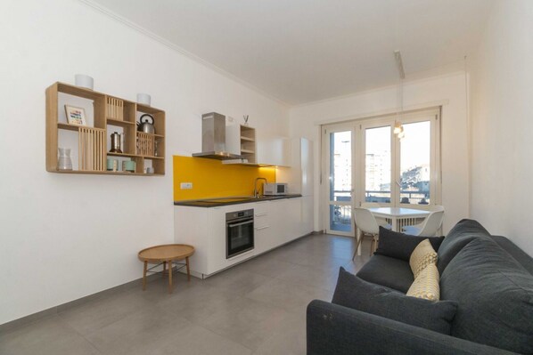 A modern apartment with a kitchen, dining area, and living room.