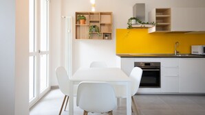 A modern kitchen with white cabinets, a yellow accent wall, and a built-in oven. - GuestHost - Comfortable studio perfect for 2 guests is located near the famous Parco del Valentino with the beautiful castle and the medieval village, a few subway stops from the historic center, near the famous Eataly, the Lingotto, the Molinette Hospit (Torino)