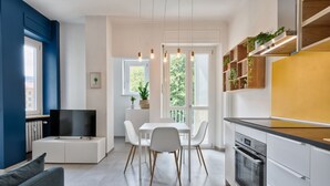 A modern kitchen with white cabinetry, a built-in oven, and a dining area with a white table and chairs. - GuestHost - Comfortable studio perfect for 2 guests is located near the famous Parco del Valentino with the beautiful castle and the medieval village, a few subway stops from the historic center, near the famous Eataly, the Lingotto, the Molinette Hospit (Torino)