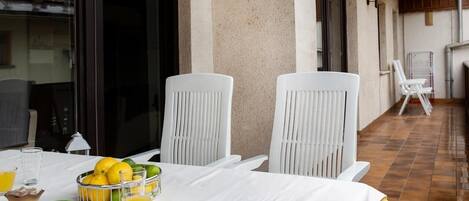 En matplats med ett bord dukat för två personer, stolar, en skål med citroner och glas med apelsinjuice.