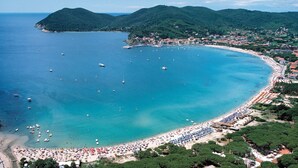 A coastal town with a beach, boats, and hills in the background. - Victoria Mobilehome Camping Ville Degli Ulivi (Campo nell'Elba)