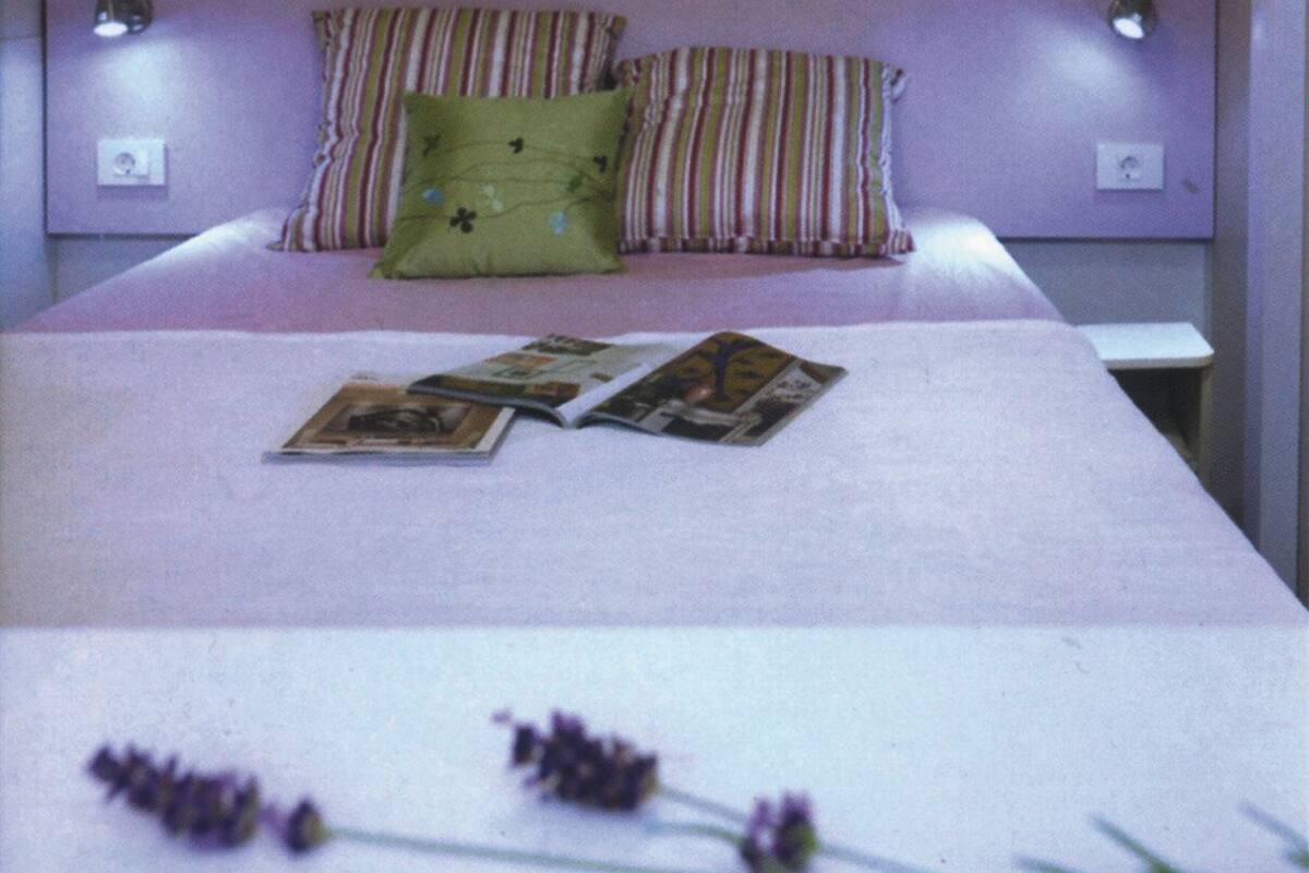Une chambre à coucher bien rangée, avec un lit, des oreillers et un magazine posé sur le lit.
