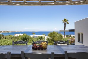 A table with a fruit basket and a view of the sea. - Villa Anemos by VillaRentalsgr (Paros)